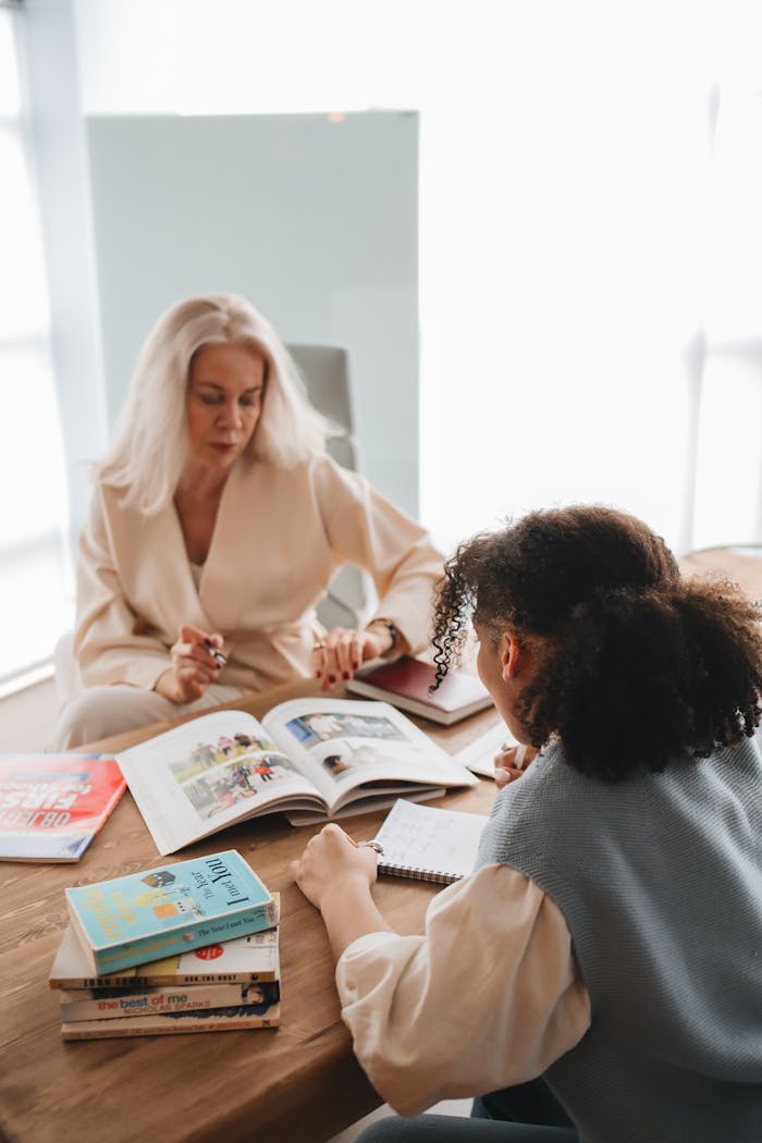 Two women studying together at a table, surrounded by books and notes, promoting learning.